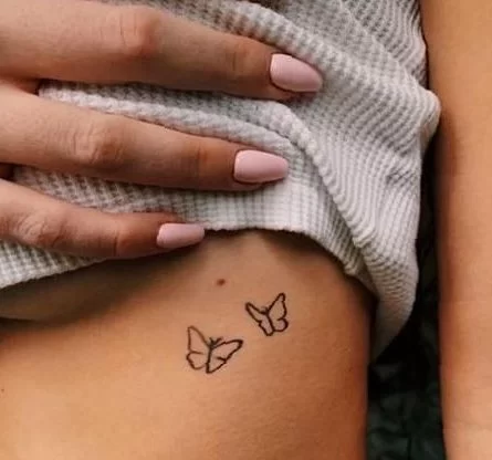 small butterfly tattoo under breast